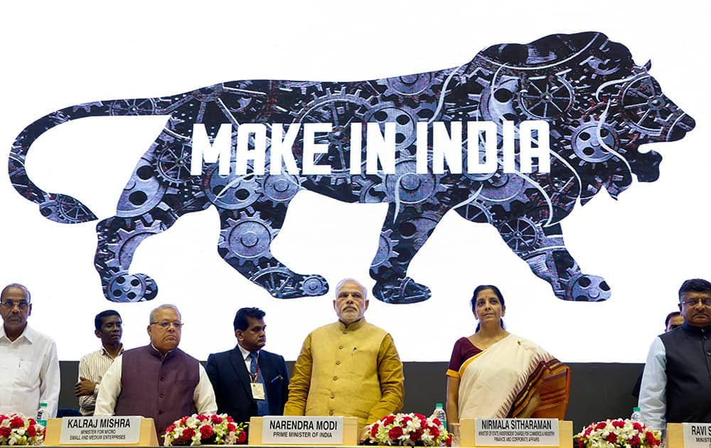 Prime Minister Narendra Modi, center, unveils the logo of 'Make in India' initiative in New Delhi.