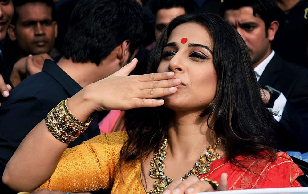 Vidya Balan gestures towards fans during a promotional event in Kolkata.