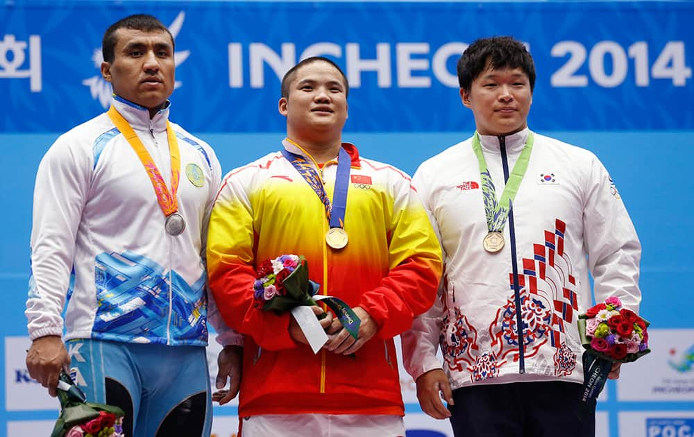 From left, silver medal winner Kazakhstan's Almas Uteshov, gold medal winner China's Liu Hao and bronze medal winner South Korea's Lee Chang-ho celebrate after winning the men's 94kg weightlifting competition at the 17th Asian Games in Incheon, South Korea.