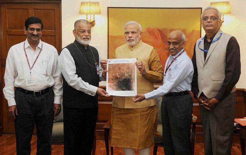 ISRO Chairman K Radhakrishnan presents an image of the surface of Mars taken by Mangalyaan to Prime Minister Narendra Modi.