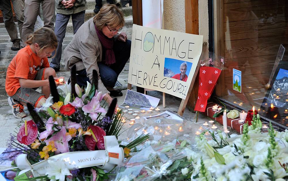 A woman and a child light candles in Saint Martin Vesubie, southern France, during a memorial gathering for French mountaineer, Herve Gourdel, who was beheaded by islamist militants in Algeria.