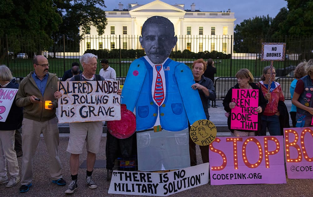 Demonstrators stand outside the White House to protest air strikes on targets in Iraq and Syria, in Washington.