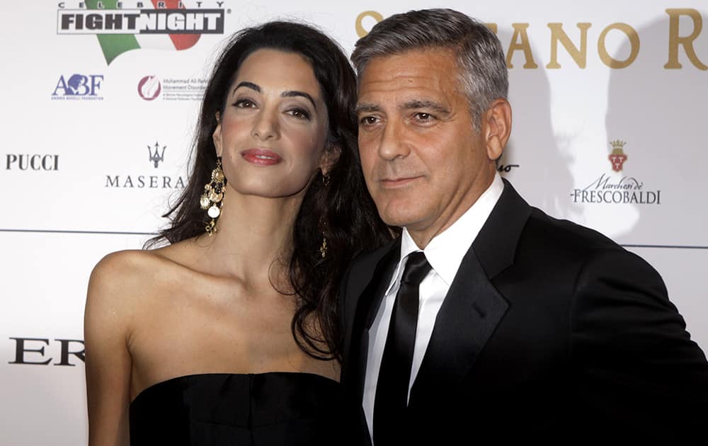 File Photo: George Clooney and his fiancee Amal Alamuddin pose for photographers as they arrive for the 'Celebrity Fight Night' foundation gala dinner, in Florence, Italy.