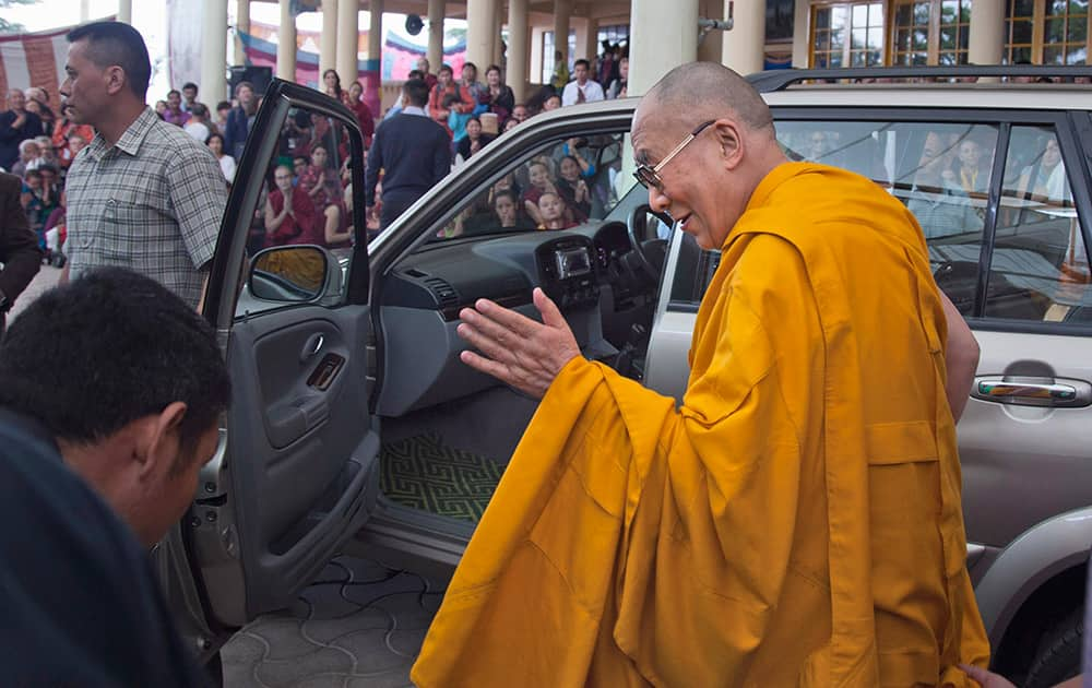 Tibetan spiritual leader the Dalai Lama, greets devotees as he prepares to leave after his religious talk at the Tsuglakhang temple in Dharmsala.