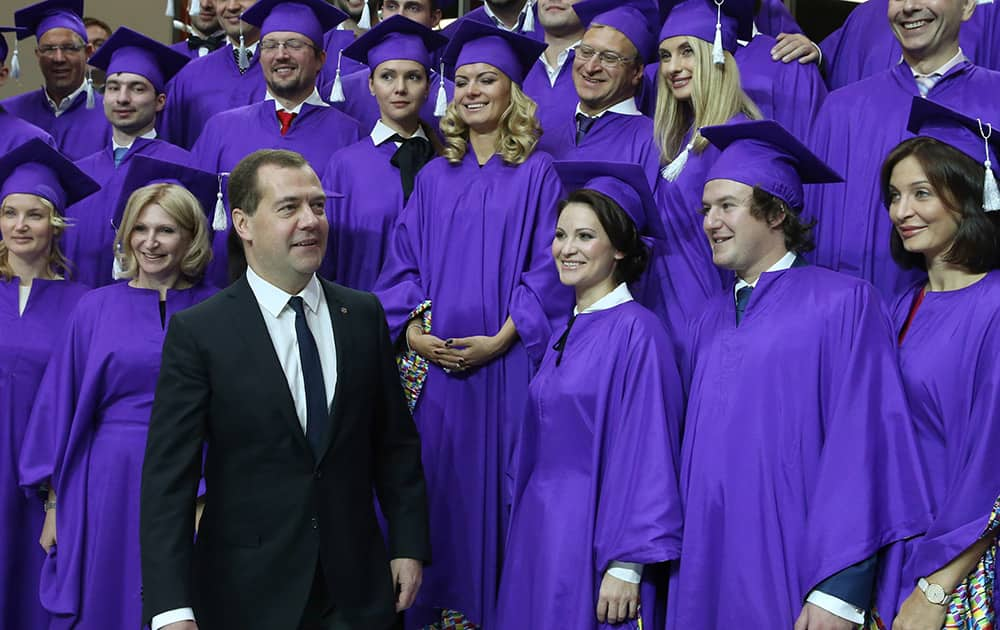 Russian Prime Minister Dmitry Medvedev, walks to pose for a photo with graduates of Moscow School of Management in Skolkovo, outside Moscow, Russia.