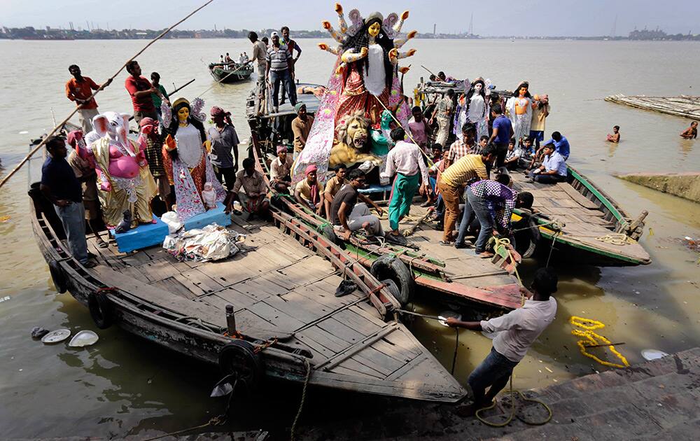 Idols of Hindu goddess Durga is carried on a country boat on the Ganges River to a venue of worship in Kolkata.