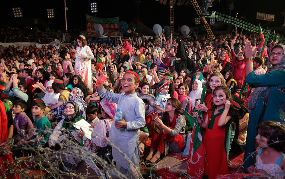 Women an children cheer for Pakistan's cricketer-turned-politician Imran Khan during an anti government protest outside the parliament building in Islamabad.