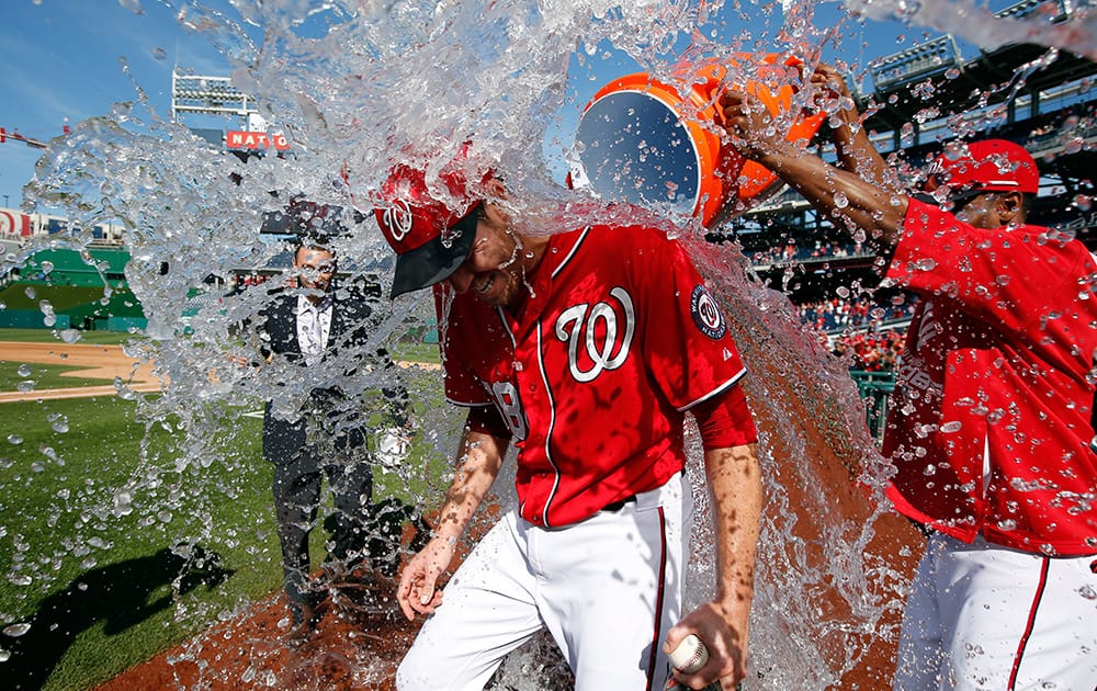 Washington Nationals starting pitcher Doug Fister, left, is doused with water by Michael Taylor after the first baseball game of a doubleheader at Nationals Park