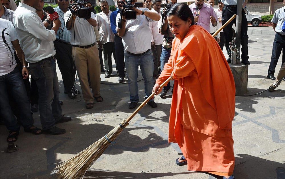 Union Water Resources Minister Uma Bharti sweeps as she takes part in Swachh Bharat Abhiyan’ (Clean India Mission) at Shram Shakti Bhavan, in New Delhi.