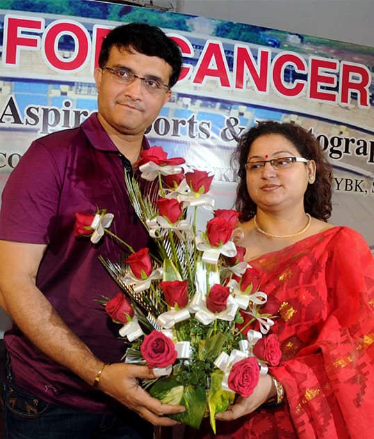 Former Indian cricket captain and co-owner of ISL franchise Atletico de Kolkata Sourav Ganguly receives a bouqet from critically ill cancer patient Pinki Roy during the announcement of a football exhibition match for financially supporting her, in Kolkata.