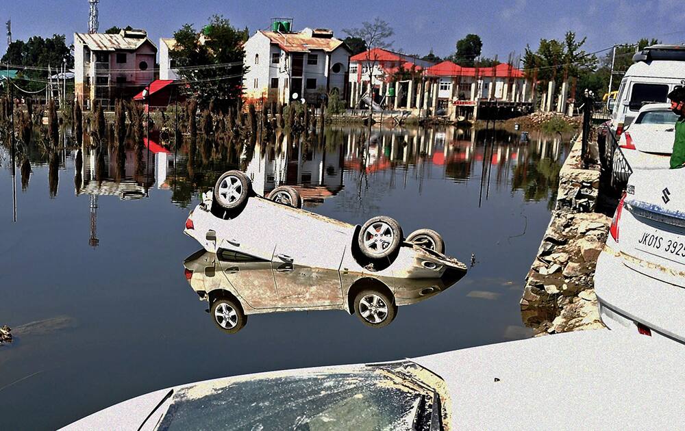 A damaged car lies half submerged at flood-hit Rajbagh area of Srinagar.