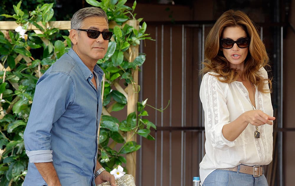 George Clooney and Cindy Crawford walk in the garden of the Cipriani hotel in Venice. Clooney, 53, and Alamuddin, 36, are expected to get married this weekend in Venice, one of the world's most romantic settings.