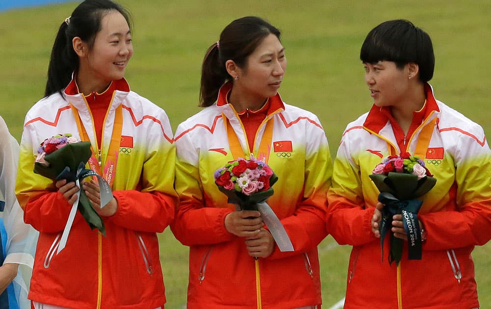 Fom left to right, China's Zhu Jueman, Xu Jing and Cheng Ming stand on the podium during the medal ceremony after winning the silver medal at the Recurve Women's Team archery competition at the 17th Asian Games in Incheon, South Korea.