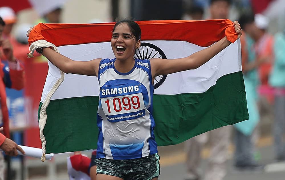 India's Kaur Khushbir holds her national flag after taking second place in the women's 20km race walk at the 17th Asian Games in Incheon, South Korea.