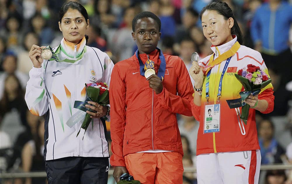 India`s Lalita Babar (l), bronze medallist in the Womens 3000 meters steeplechase with gold medallist Bahrains Ruth Jebet, and silver medalist Chinas Li Zhenzhu on the podium at the at the 17th Asian Games.