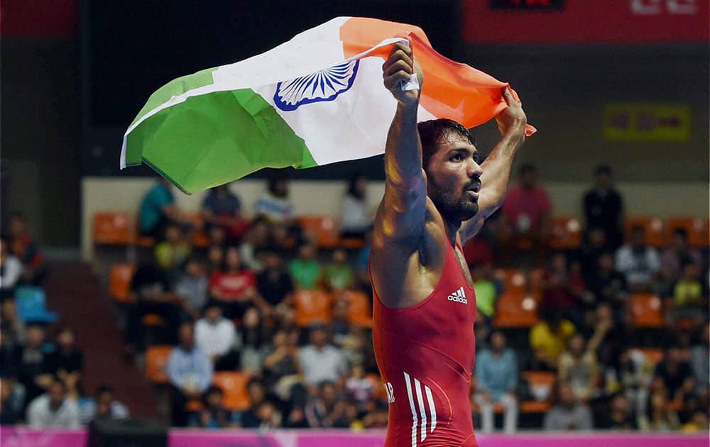 Indi`s Yogeshwar Dutt holds the tricolour after defeating Tajikistans Zalimkhan Yusupov, winning gold medal in the mens 65 kg freestyle wrestling match at Dowon Gymnasium Stadium at 17th Asian Games.