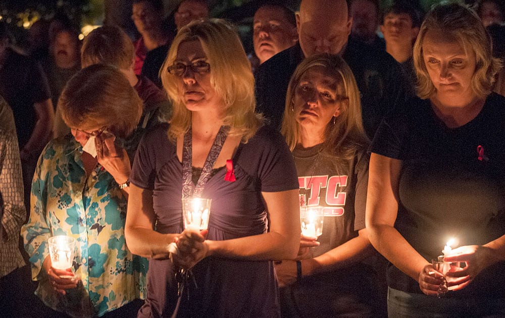 Doris Floyd, far left, Sherry Smith, second from left, Wendy Perkins, second from right, and Susan Decker attend at a candlelight vigil at North Central Texas College in Gainesville, Texas, for four members of the school softball team who were killed in a highway collision while returning from a scrimmage game in Oklahoma two days before.