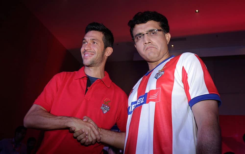 Spanish soccer star Luis Garcia, left poses with former Indian cricket captain and co owner of the Atletico De Kolkata football club of the Indian Super League (ISL) in Kolkata.