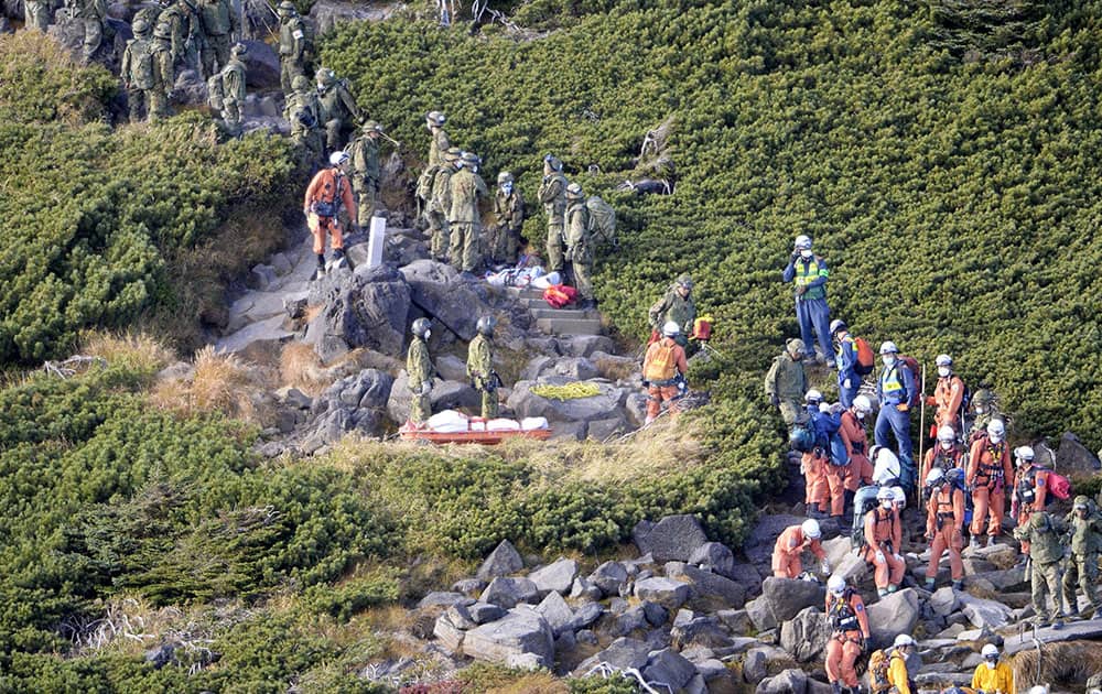 Firefighters and members of the Japan Self-Defense Forces descend Mount Ontake after they called off a search operation due to noxious fume in central Japan.