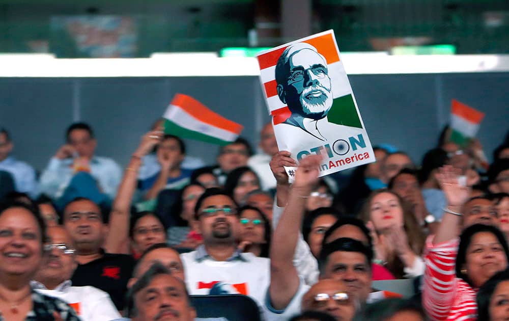 Supporters cheer and wave Indian flags as India's Prime Minister Narendra Modi gives a speech during a reception by the Indian community in honor of his visit to the United States at Madison Square Garden.