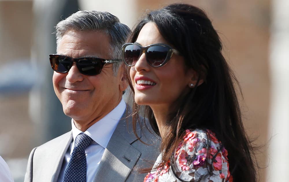 George Clooney is flanked by his wife Amal Alamuddin as they leave the Aman luxury Hotel in Venice, Italy.