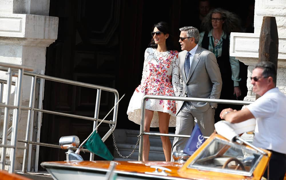 George Clooney is flanked by his wife Amal Alamuddin as they leave the Aman luxury Hotel in Venice, Italy.