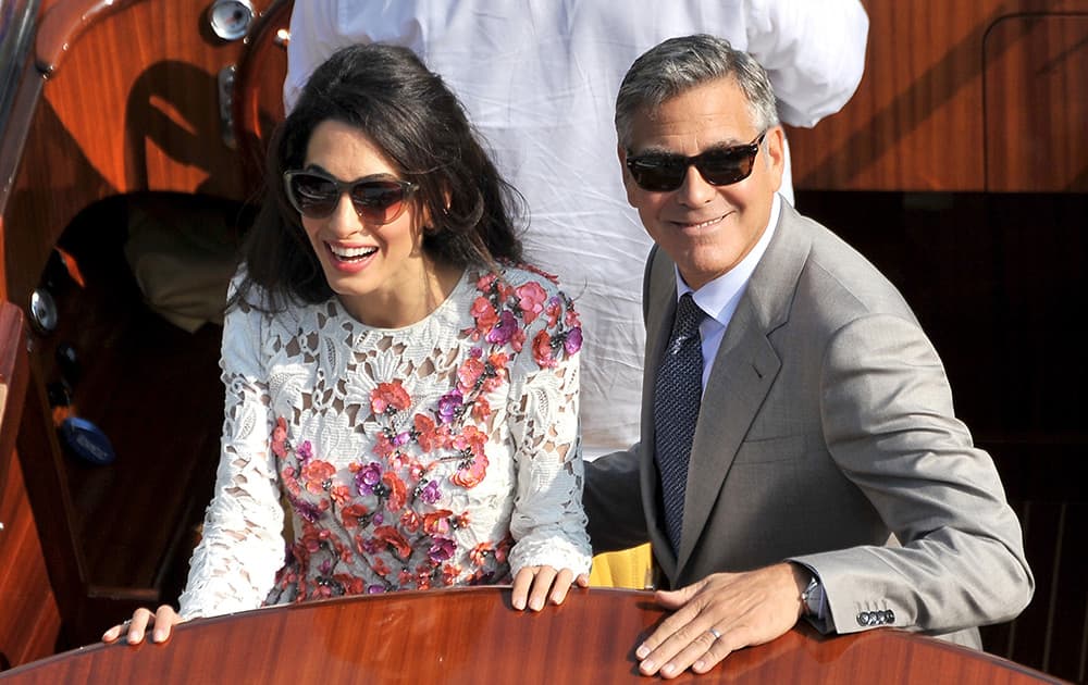 George Clooney and his wife Amal Alamuddin, cruise the Grand Canal after leaving the Aman luxury Hotel in Venice, Italy.