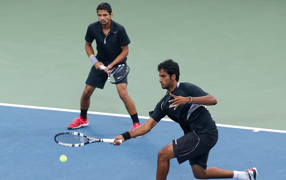 India's Saketh Sai Myneni, bottom, and Sanam Krishan Singh return a shot to South Korea's Lim Yongkyu and Chung Hyeon during the men's doubles gold medal tennis match at the 17th Asian Games in Incheon, South Korea.