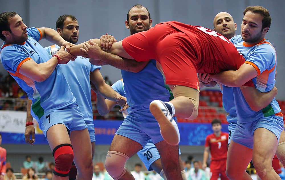 Thailand's Phuwanai Wannasaen, in red jersey, is caught by India team, in blue jersey, during the men's team kabbadi preliminary match at the 17th Asian Games in Incheon, Korea. India won 66-27.