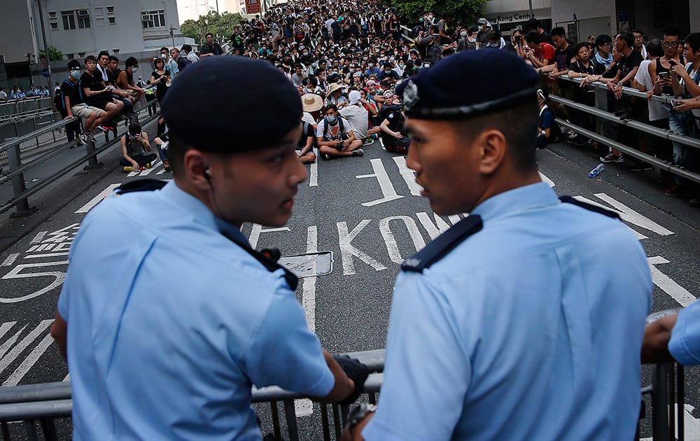 Pro-democracy protesters sit on a road as they face-off with local police in Hong Kong. Pro-democracy protesters expanded their rallies throughout Hong Kong on Monday, defying calls to disperse in a major pushback against Beijing's decision to limit democratic reforms in the Asian financial hub. 