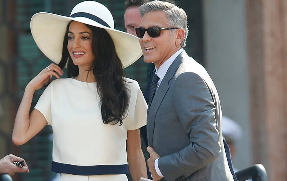 George Clooney, flanked by his wife Amal Alamuddin, arrives at the city hall for their civil marriage ceremony in Venice, Italy.