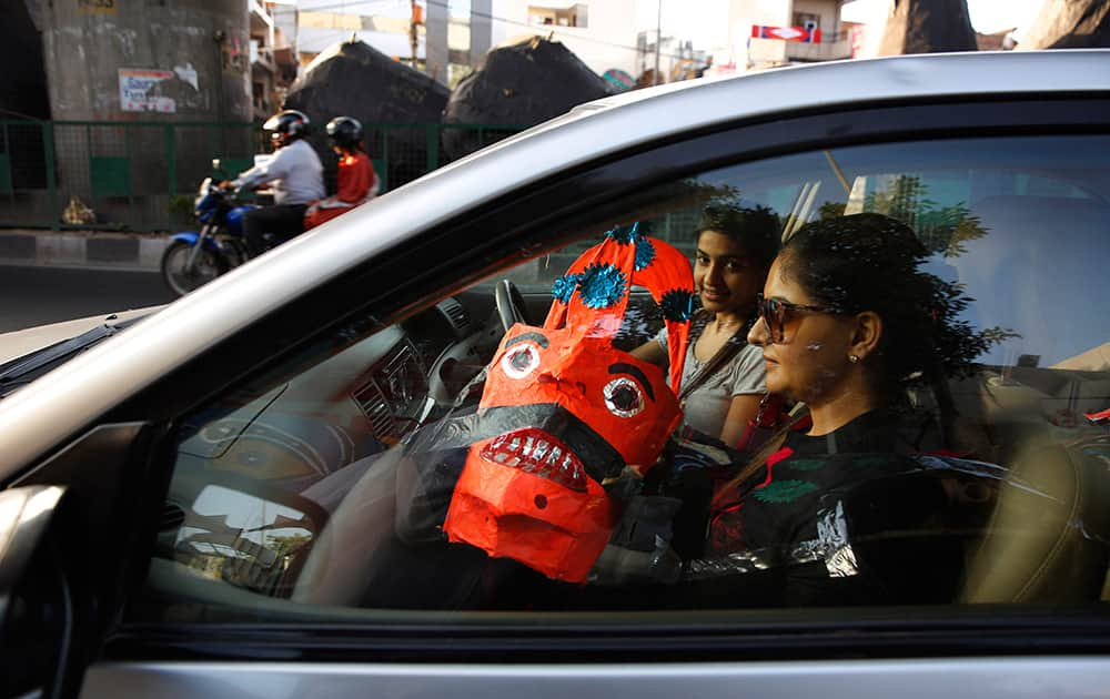 Women drive home after buying an effigy of mythical demon king Ravana as part of Dussehra festivities in New Delhi.