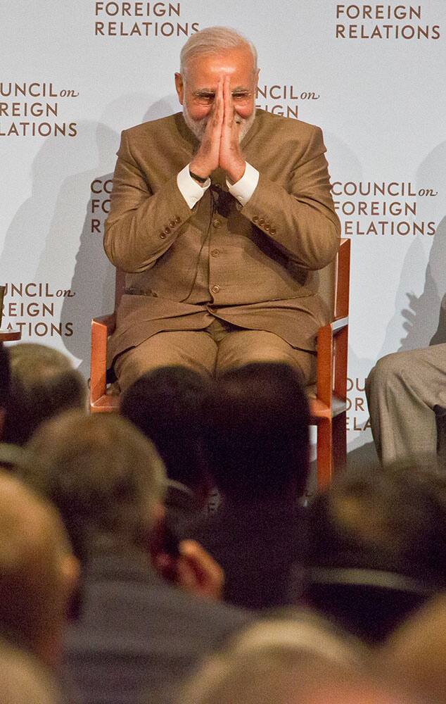 India's Prime Minister Narendra Modi, right, clasps his hands and bows as he ends his visit to the Council on Foreign Relations.