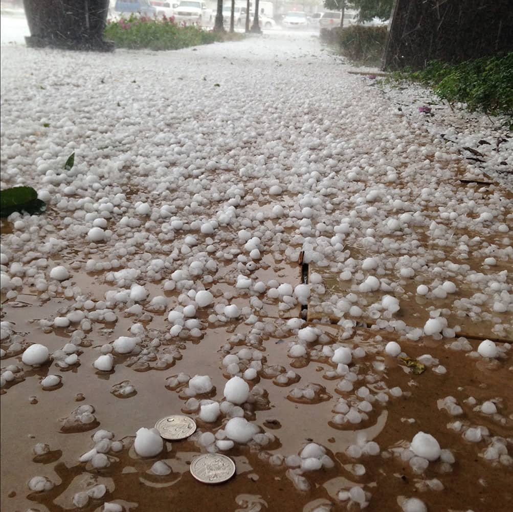 In this photo provided by local resident Joe Macauley shows, large hailstones are collect in the streets of Greenwood Village suburb of Denver, Colo.