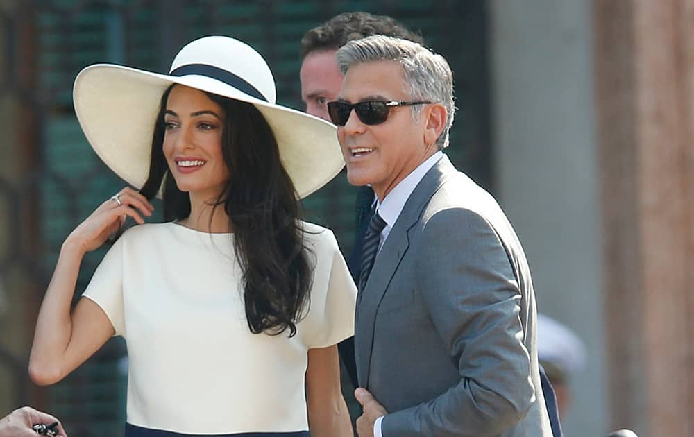 George Clooney, flanked by his wife Amal Alamuddin, arrives at the city hall for their civil marriage ceremony in Venice, Italy.