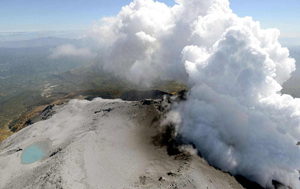 An aerial view shows volcanic smoke and fume raising from craters of Mount Ontake, central Japan.