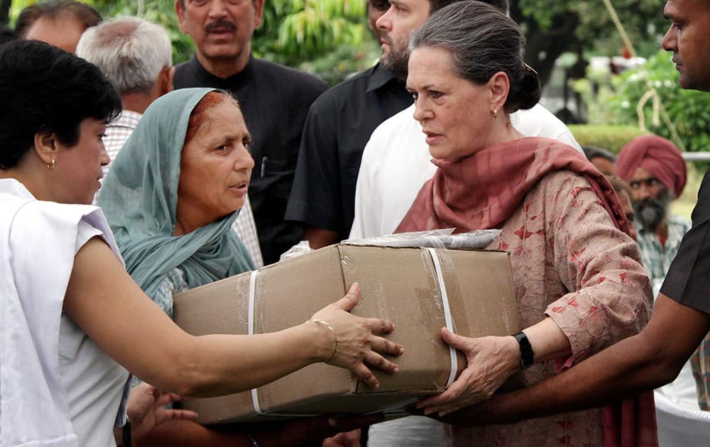 Congress President Sonia Gandhi along with party Vice President Rahul Gandhi and senior leader Ghulam Nabi Azad distributing relief packets to flood affected people in Jammu.