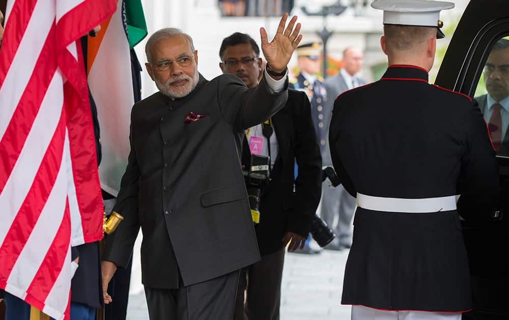 Indian Prime Minister Narendra Modi waves as he arrives at the White House, for a meeting with President Barack Obama in the Oval Office.