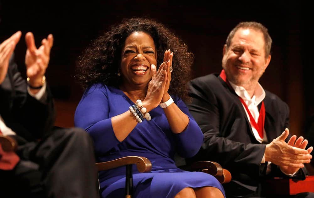 Actor, talk show host and philanthropist Oprah Winfrey, center, applauds along with film producer Harvey Weinstein, right, as Winfrey is introduced moments before accepting the W.E.B. Du Bois medal during ceremonies, on the campus of Harvard University, in Cambridge, Mass. 