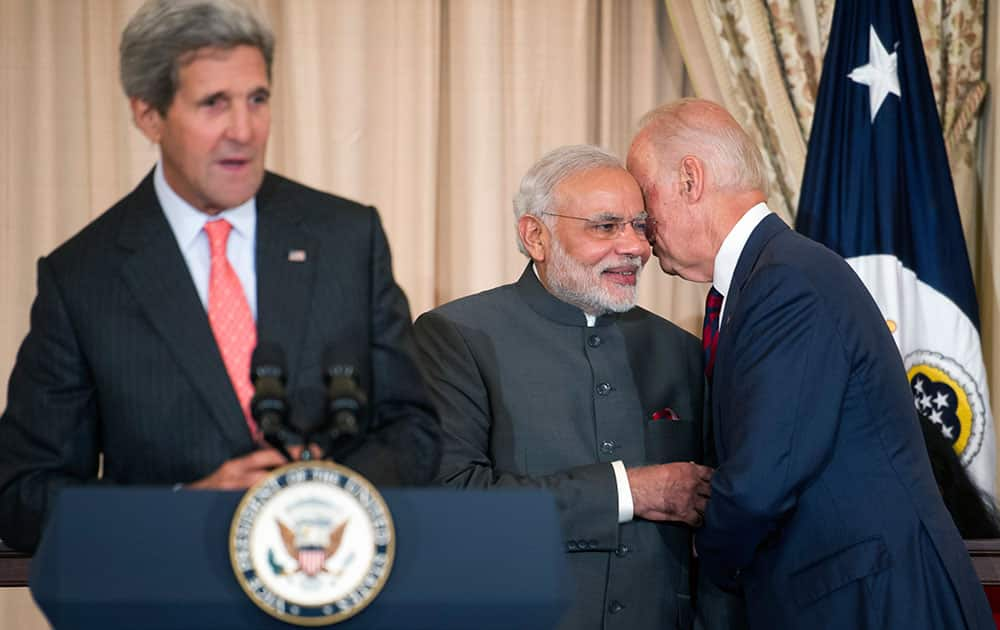 Indian Prime Minister Narendra Modi, center, talks with Vice President Joe Biden as Secretary of State John Kerry speaks during a luncheon at the State Department in Washington.