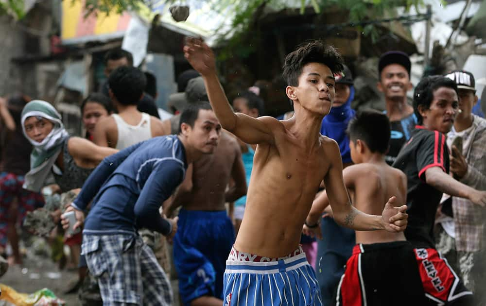 Informal settlers throw rocks and bottles at police and demolition crew to resist the demolition of their shanties in suburban Mandaluyong east of Manila, Philippines.