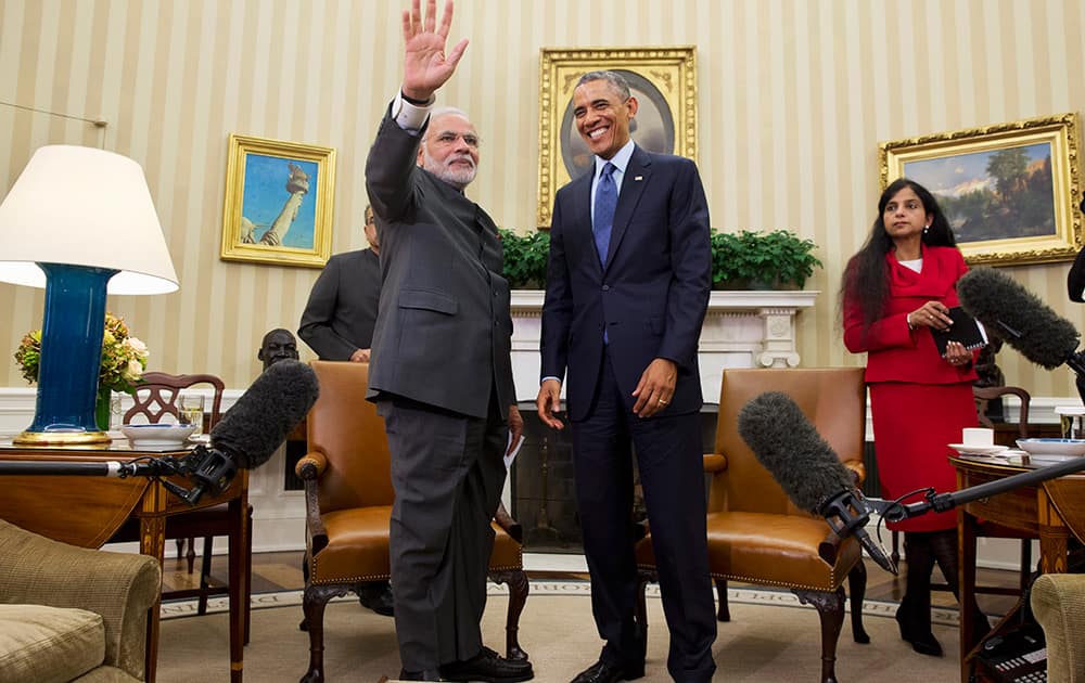 Indian Prime Minister Narendra Modi waves as he meets with President Barack Obama, in the Oval Office  of the White House in Washington.