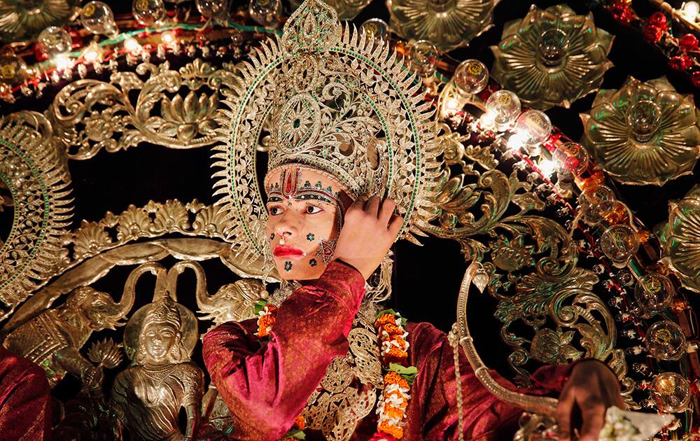 A artist dressed as Hindu god Rama sits on a float during a Dussehra festival procession in the northern Indian city of Allahabad.