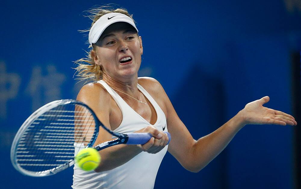 Maria Sharapova of Russia returns a shot against Carla Suarez Navarro of Spain during the China Open tennis tournament at the National Tennis Stadium in Beijing, China.