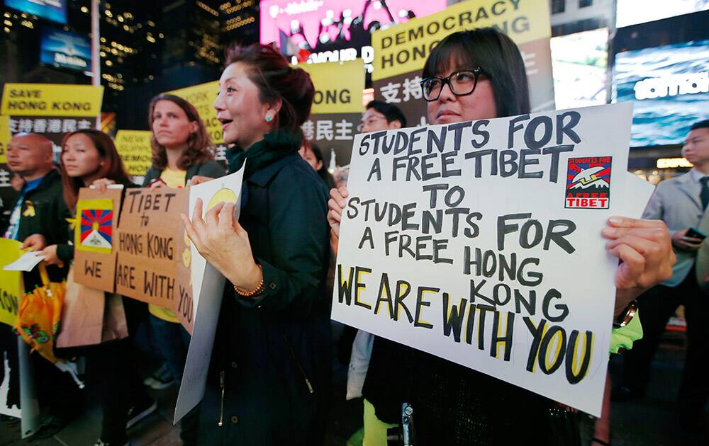 Protesters hold signs during a rally, in New York's Times Square to demand a stop to violent police repression of Hong Kong democracy activists.