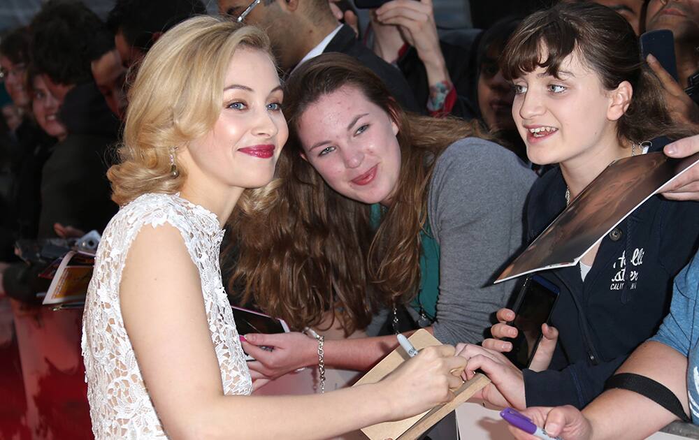 Actress Sarah Gadon signs autographs for fans as she arrives for the premiere of the film Dracula Untold in central London.