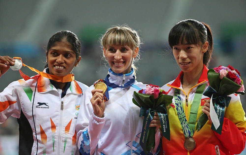 Gold winner Kazakhstan's Margarita Mukasheva, center, silver winner India's Tintu Lukka, left and bronze winner China's Zhao Jing, pose during the medal ceremony of the women's 800m final at the 17th Asian Games in Incheon, South Korea.