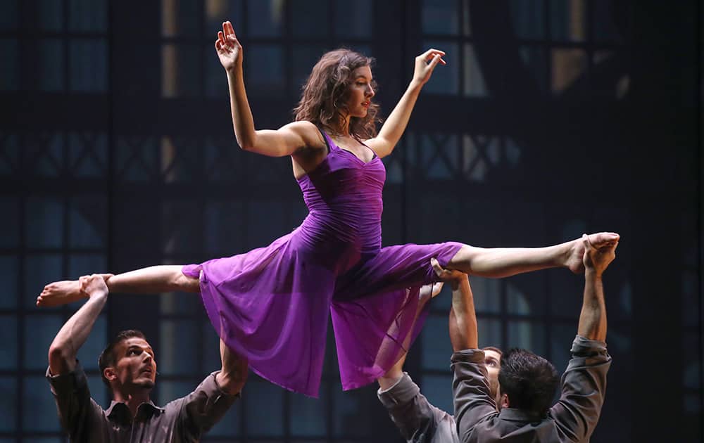 Myriam Deraiche of the Canadian troupe Cirkopolis is supported by fellow cast members as they perform during a dress rehearsal at the Sydney Opera House in Sydney, Australia.