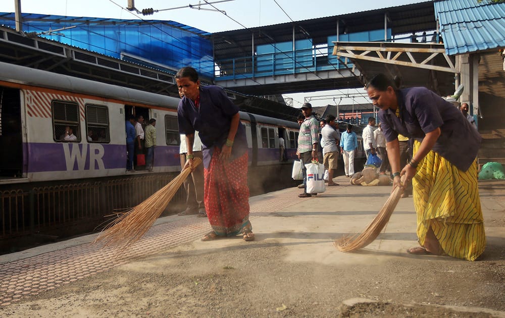 Workers clean a train station in Mumbai.