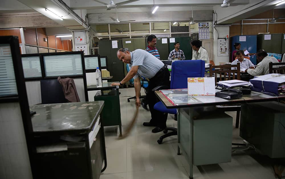 An Indian railways official cleans his office in Mumbai.